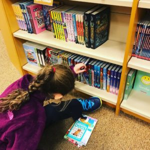 Girl looking at books in store